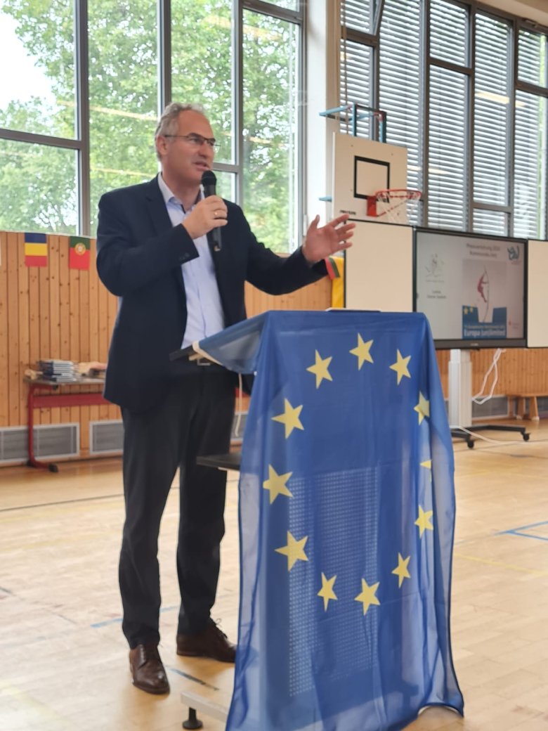 Dietmar Seefeldt am Rednerpult, eine EU-Flagge ist zu sehen.